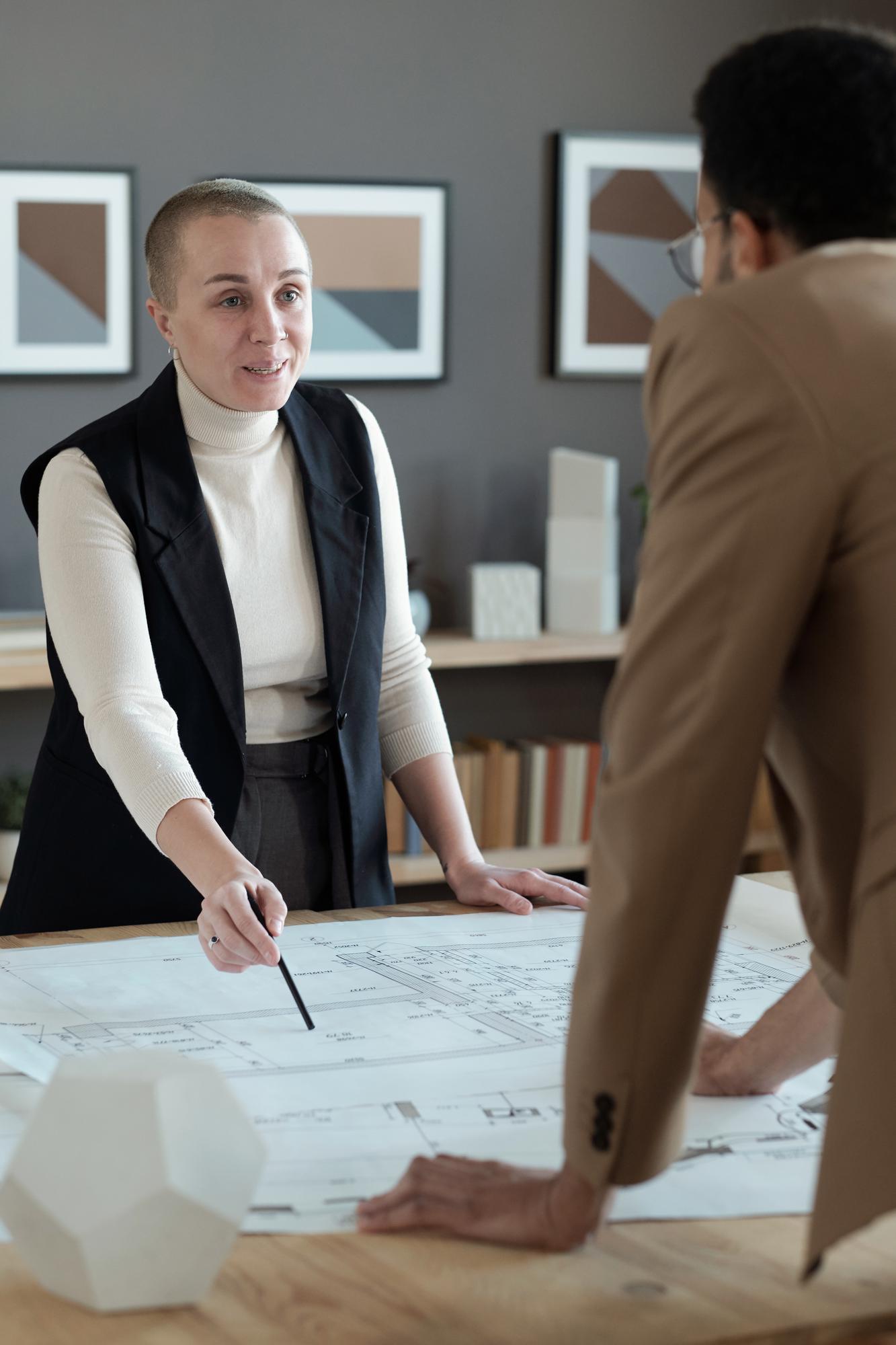 Consultant imobiliar arătând planuri unui cuplu